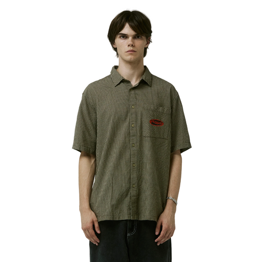 Person wearing a green checkered shirt with a red logo on a gray background
