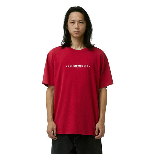 Person wearing a red t-shirt with text on a plain background